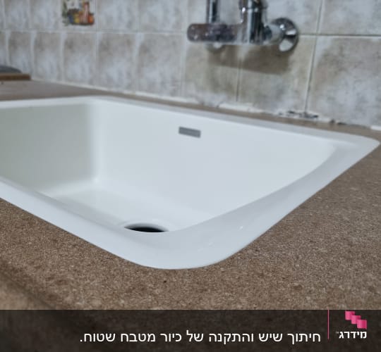 שיש חום ליד כיור לבן במטבח